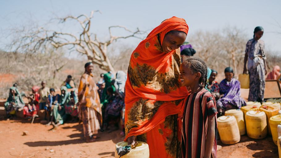 A mother and daughter stood beside each other laughing.