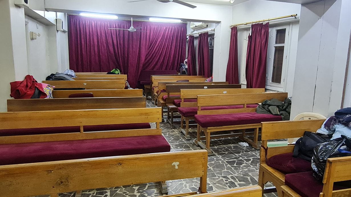 Inside of a church building with light wooden pew