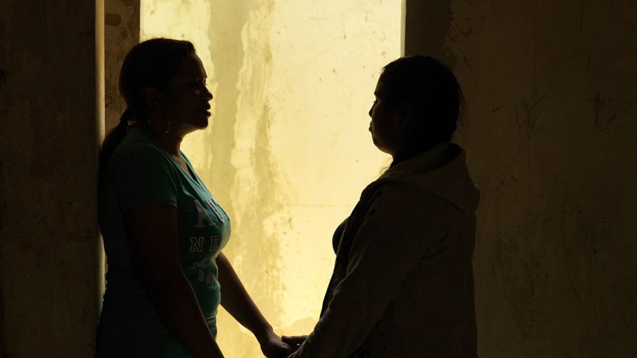 Silhouette of two women standing in a doorway