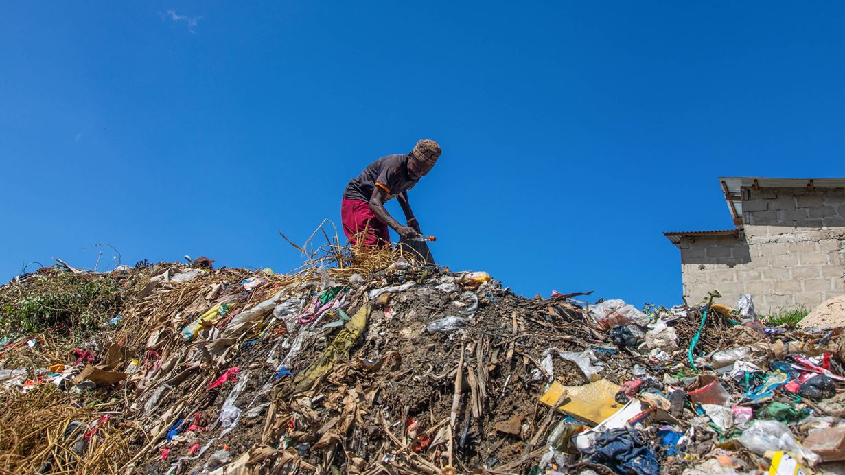 Kigogo, Dar es salaam Tanzania - Jonsoni Pita, a waste  picker, picking waste along the riverbank.