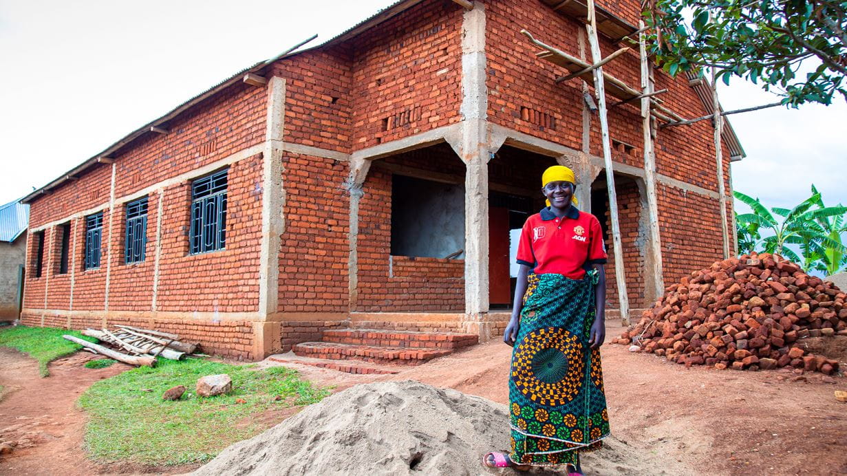 A woman stood in front of a health centre under construction.