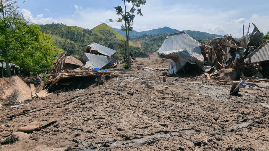 Mud covers the remains of houses destroyed by flooding and landslides in DRC, 4 May 2023