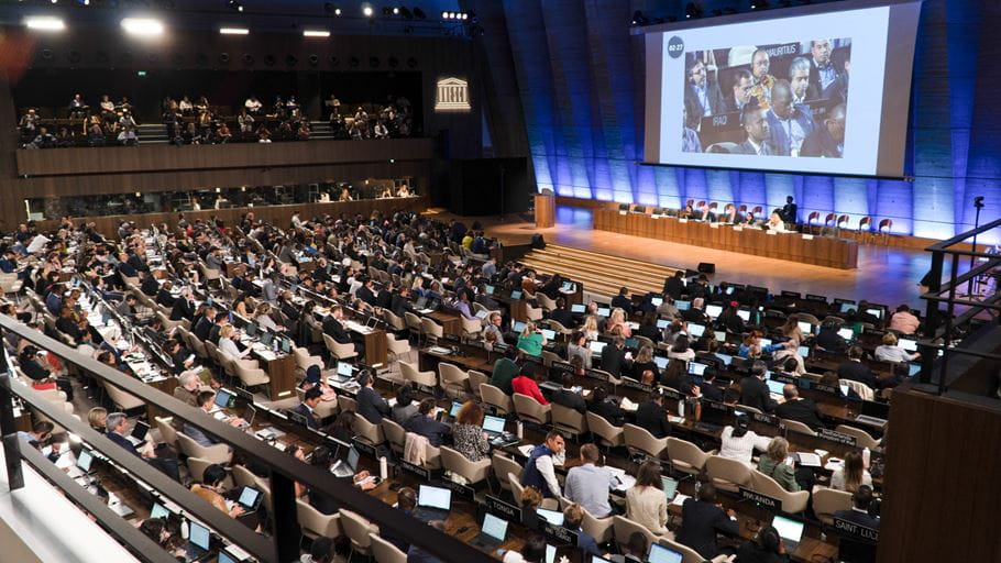A conference auditorium full of delegates from around the world attend negotiations at INC-2 in Paris