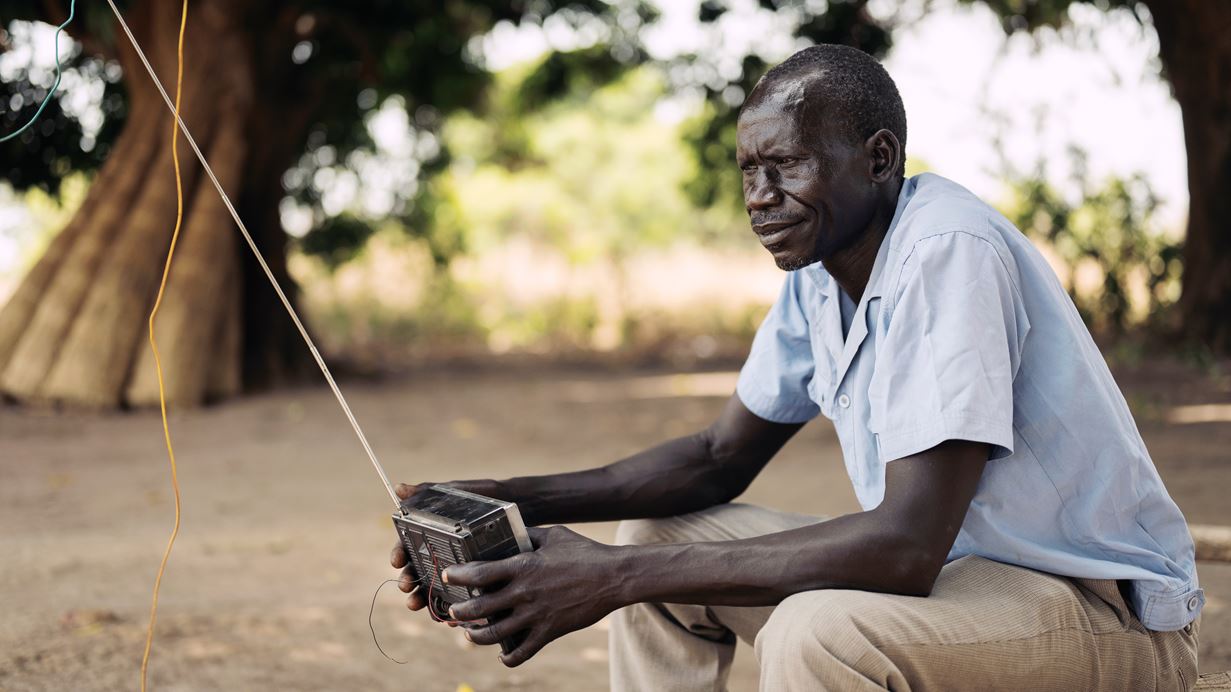 Julius sits on a bench and listens to his radio 