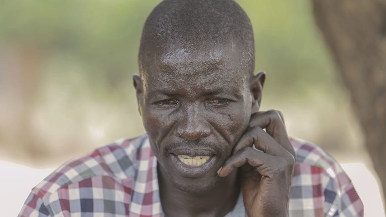 John looks thoughtful as he shares his story of how he has transformed his circumstances with the support of Tearfund's Transforming Communities programme.