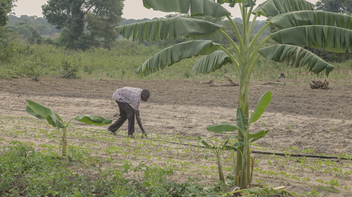John prepares his irrigation pipes which deliver water from the pump that he has been able to install with a manageable loan from Tearfund's local partner.