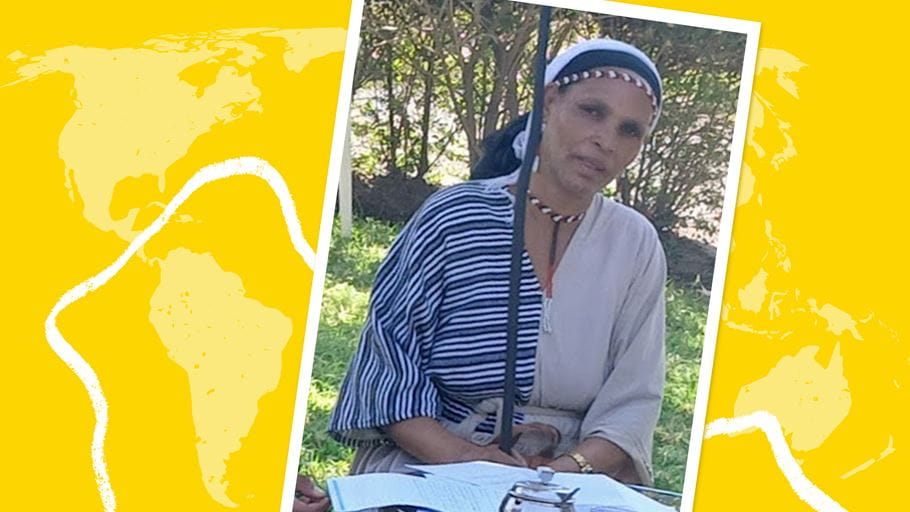 A woman, Hawi, is sat at a table with papers on it.