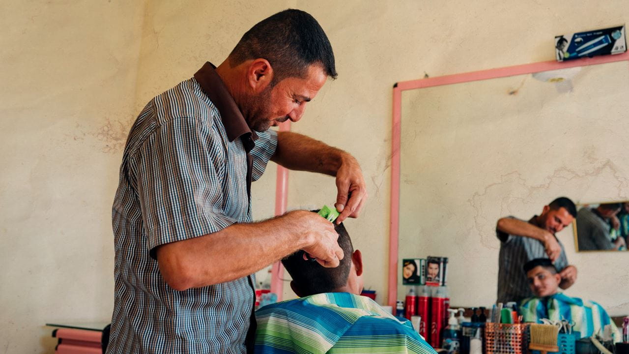 Abdullah back at work in his barber’s shop.